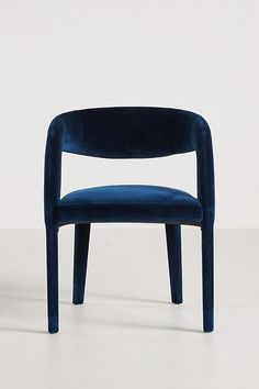 a blue chair sitting on top of a white floor next to a black object in the background