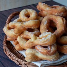 a basket filled with sugar covered donuts on top of a table