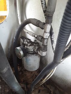 an old water heater with hoses attached to it