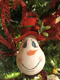 a snowman ornament hanging from a christmas tree