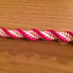 a pink and white rope on top of a wooden table