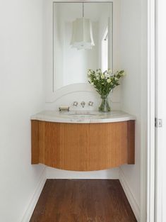 a bathroom with a sink, mirror and wooden floor