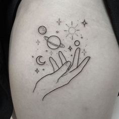 a woman's thigh with an outline of two hands reaching for the stars and planets