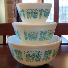 three bowls stacked on top of each other in front of a wooden table with windows