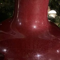 a large red vase sitting on top of a table