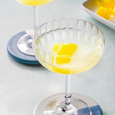 two glasses filled with yellow liquid on top of a table