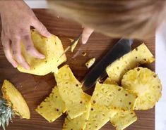 someone cutting up some pineapples on a cutting board