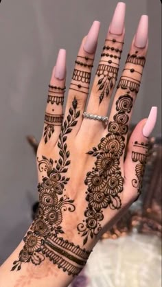 a woman's hand with henna tattoos on it