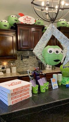 the kitchen counter is covered with boxes and decorations for an alien themed birthday party at home