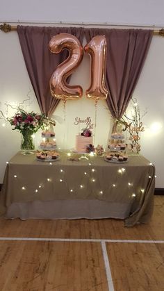 a table topped with lots of cupcakes and cake next to a number twenty sign