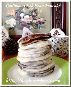 stack of pancakes sitting on top of a green plate