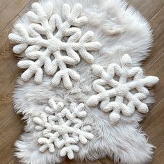 white snowflakes are arranged on a furry rug