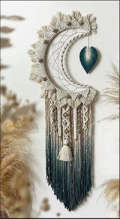 a decorative wall hanging with a heart and tassels on the top of it