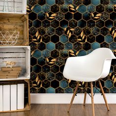 a white chair sitting in front of a wall covered in hexagonal tiles and gold leaves