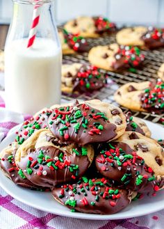 chocolate covered cookies with sprinkles on a plate next to a glass of milk