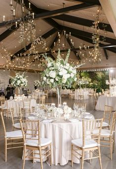 the tables are set with white linens and centerpieces for an elegant reception