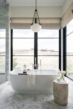 a large white bath tub sitting next to a window