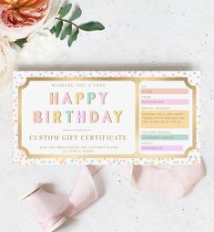 a birthday gift certificate sitting on top of a table next to some pink and white flowers