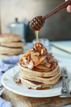 a stack of pancakes with syrup being drizzled on top