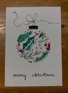 a christmas card with a holly ornament on it