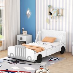 a child's bedroom with blue walls and white furniture, including a toy car bed