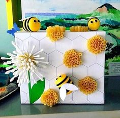 some paper flowers and bees on a table