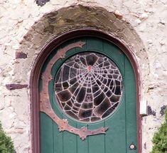 a green door with a spider web on it