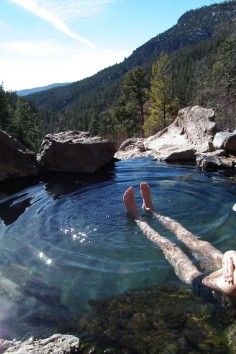 a man laying on the rocks in a hot tub