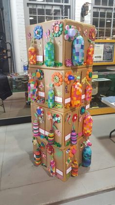 a cardboard tower made to look like it has many decorations on it and is in the middle of a room