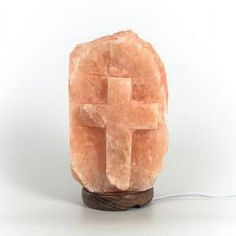 a stone cross on a wooden stand with a cord plugged into the charger