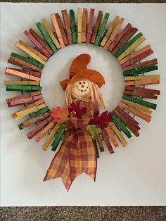 a colorful fall wreath with a scarecrow doll