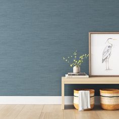 a room with blue wallpaper and two baskets on the floor next to a table