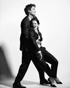 a man and woman are dancing together in black and white, one is holding the other's leg