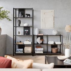 a living room filled with furniture and a book shelf next to a wall mounted vase