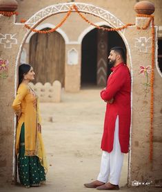 a man and woman standing in front of an archway