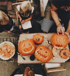 people carving pumpkins with carved faces on them