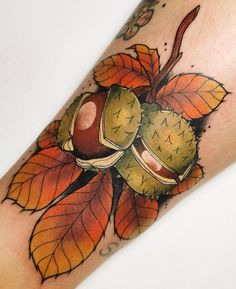 a tattoo with leaves and acorns on it