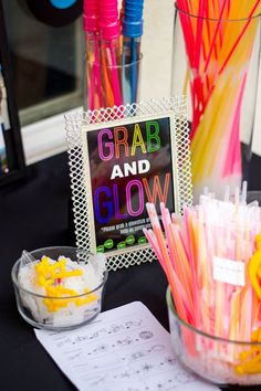 there are many different colored straws in the glass bowl on the table next to the sign that says grab and glow