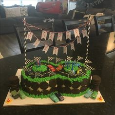 a birthday cake is decorated with racing cars