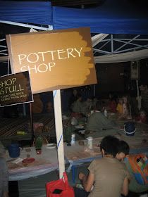 there are many people sitting at the pottery shop