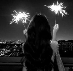 a woman is looking at fireworks in the sky