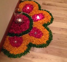 an arrangement of flowers and candles on the floor