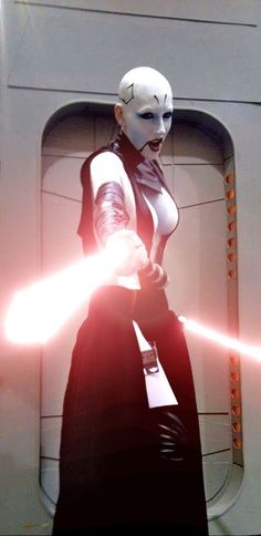 a woman dressed as darth vader in star wars the old republic, holding two lightsabes