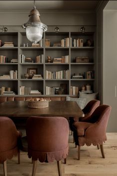 a dining room table and chairs with bookshelves in the background