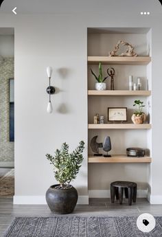 a living room filled with lots of furniture next to a wall mounted clock and potted plant