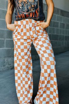 Our mid-rise Checkmate Pants are here to take trousers to another level. With a comfy elastic waistband and a wide-leg fit, they'll have you looking stylish and feeling cozy! Perfect for a casual day out, the washed black and white checkered print creates a bold and stylish look. Go ahead, make your move! Mid-rise waist Comfy elastic waistband Wide leg fit Camel and white checkered print 80% Polyester, 15% Rayon, 5% Spandex See Lily's sizing HERE, she is wearing size Small See Margie's sizing HERE, she is wearing size Large Wide Leg Lounge Pants, Checkered Pants, Casual Sweatpants, Wide Leg Sweatpants, Checkered Print, Clubwear For Women, Loose Trousers, Casual Trousers, Y2k Streetwear