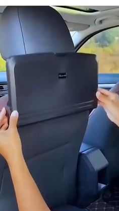 two hands are holding the back seat of a car, while another person is driving