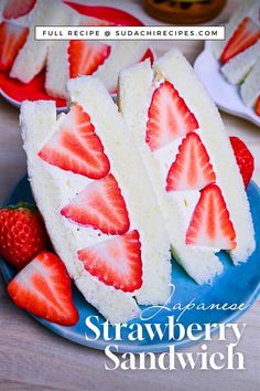 Two triangle sandwiches made with white bread filled with strawberries and cream (Japanese ichigo sando) on a blue plate