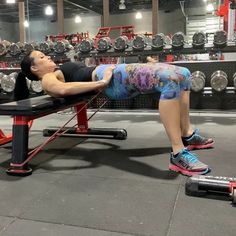 a woman is doing push ups on a bench