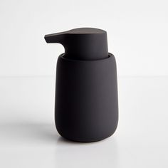 a black soap dispenser on a white surface